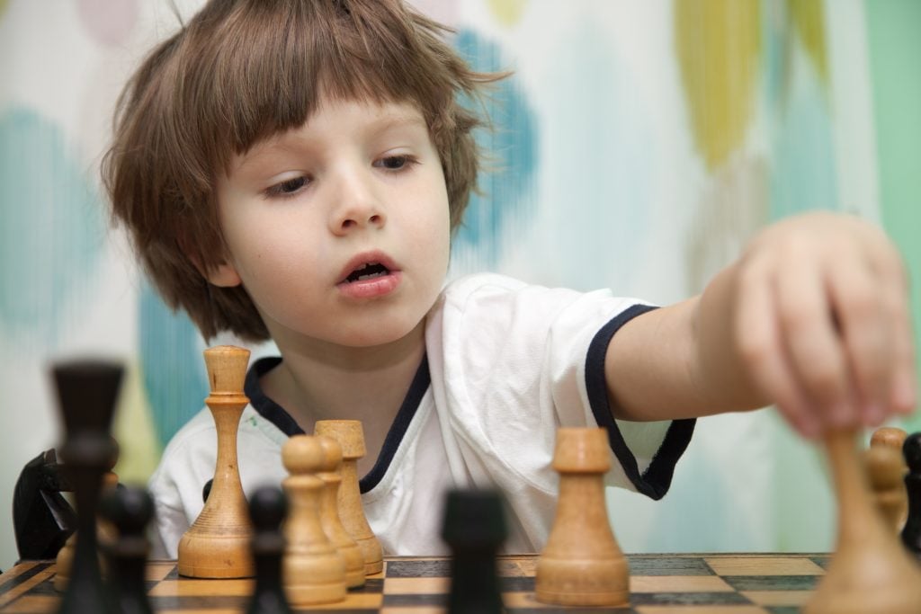 Portrait of a little boy playing chess